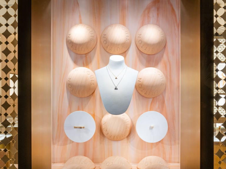 Jewellery window display with sculpted wooden spheres and a necklace bust
