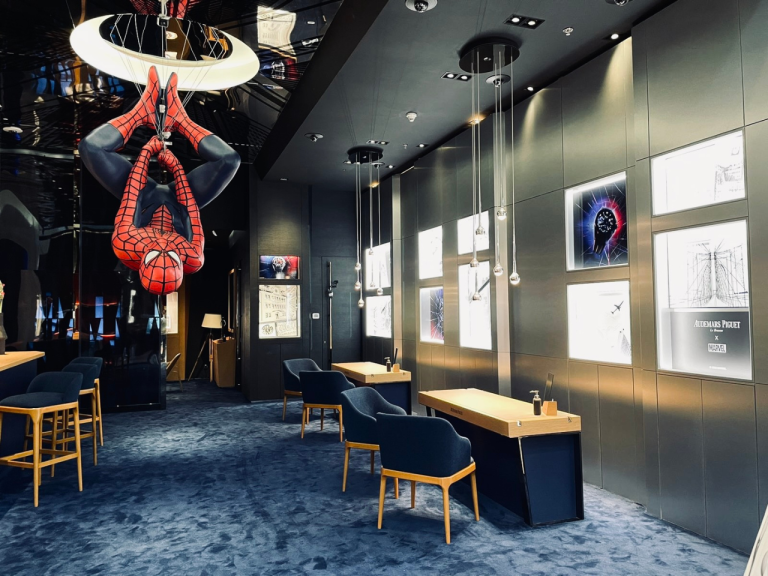 Boutique lounge with a suspended handbag feature, seating and artwork