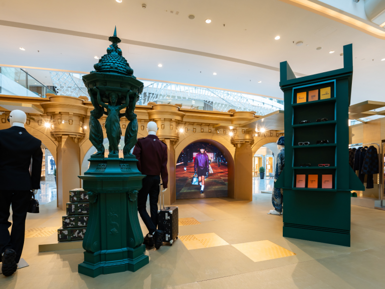 Mall concourse installation with a sculpted green fountain and archway joinery