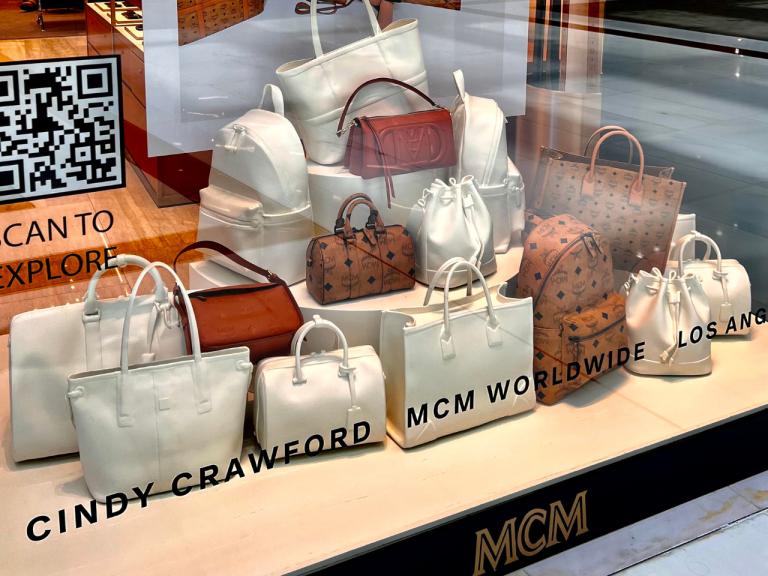 MCM x Cindy Crawford handbag window display with printed signage panels
