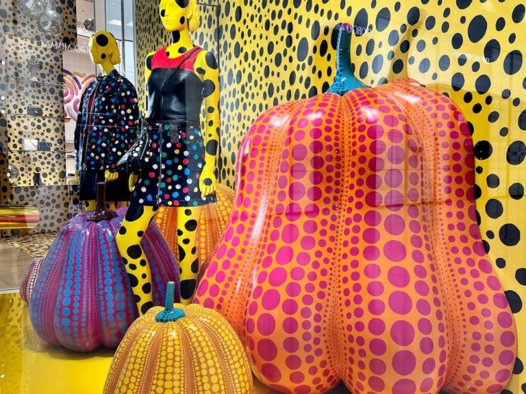 Polka-dot pumpkin sculptures and mannequins in a yellow patterned window display